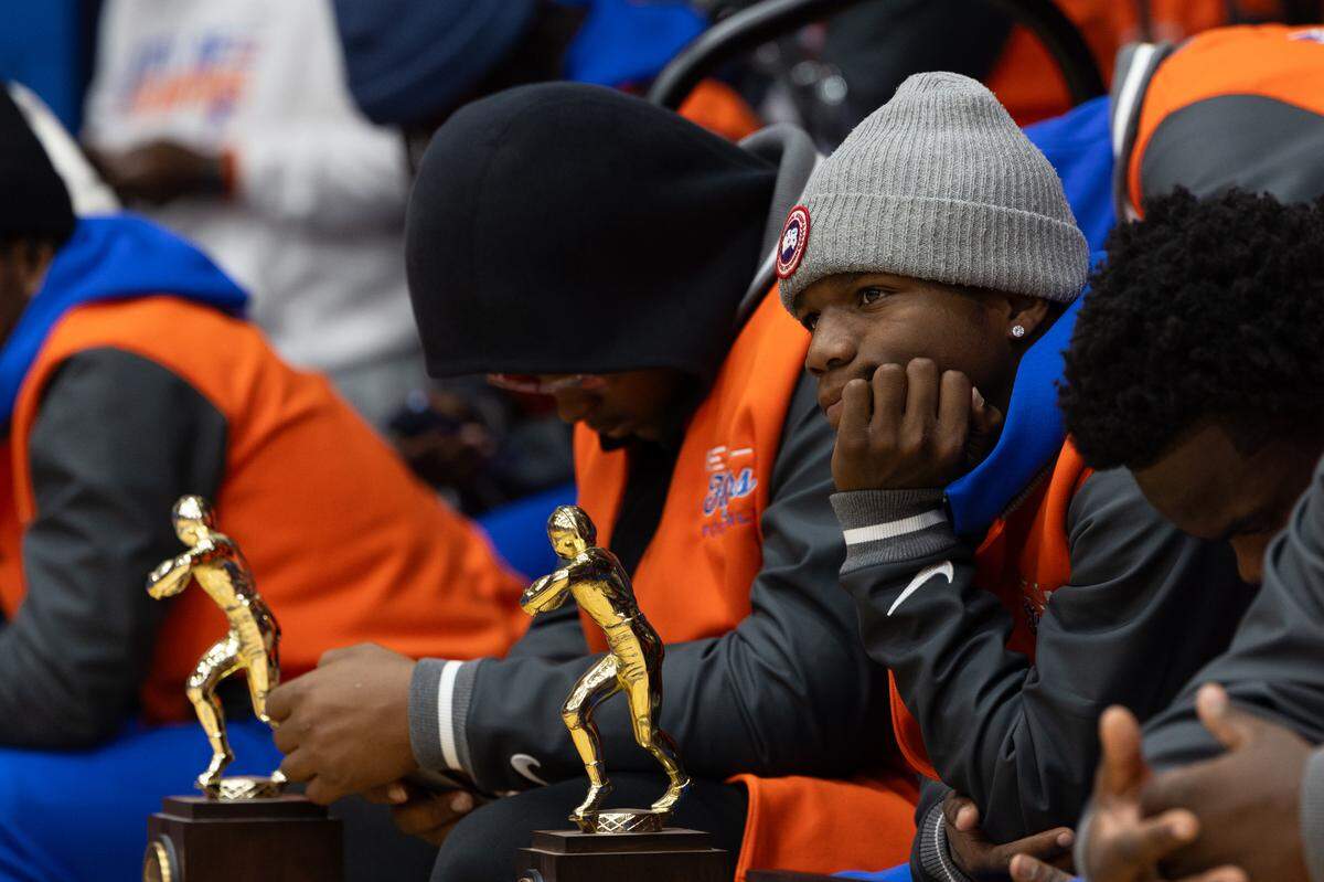 East St. Louis football players stare on as their coach, Darren Sunkett boasts of how hard they worked over the year.