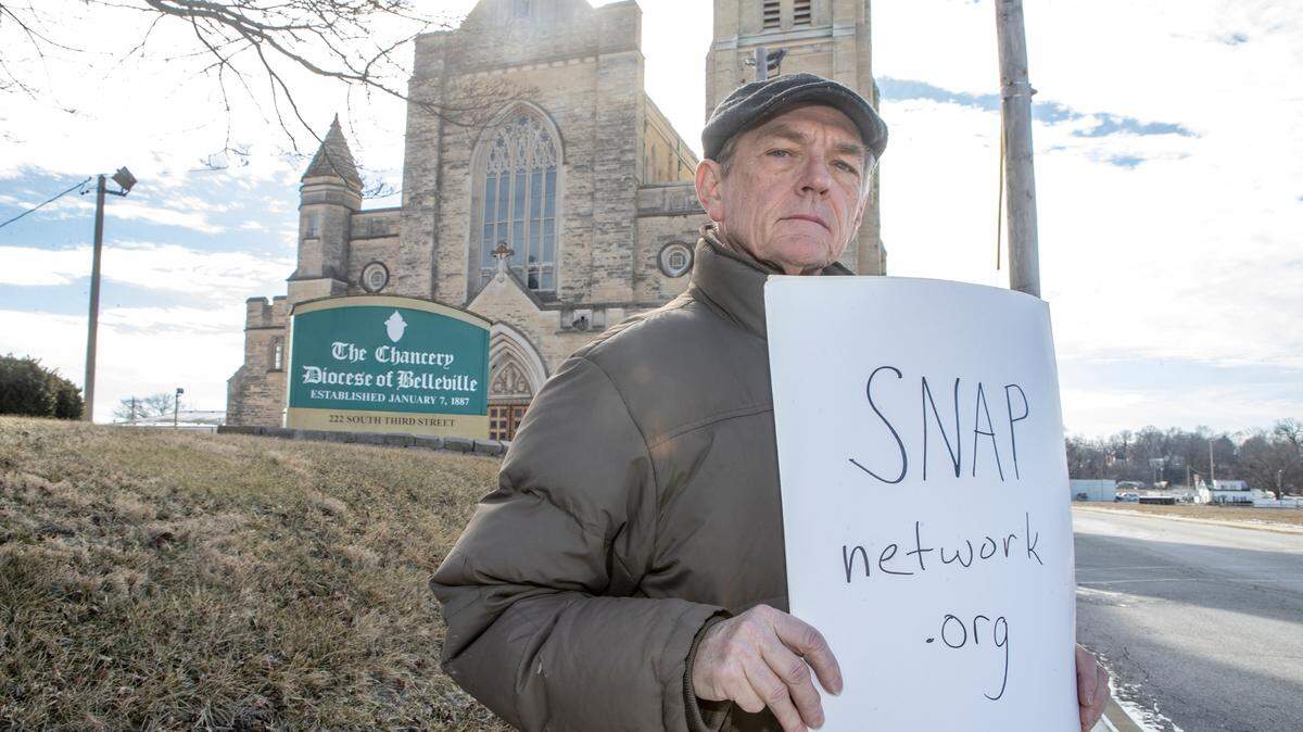 Dave Clohessy poses outside the The Chancery - Diocese of Belleville and The Cathedral of Saint Peter in Belleville. Clohessy has left his official role as National Director of SNAP (Survivors Network of Those Abused by Priests), but continues to advocate for victims and is a leading voice for survivors.