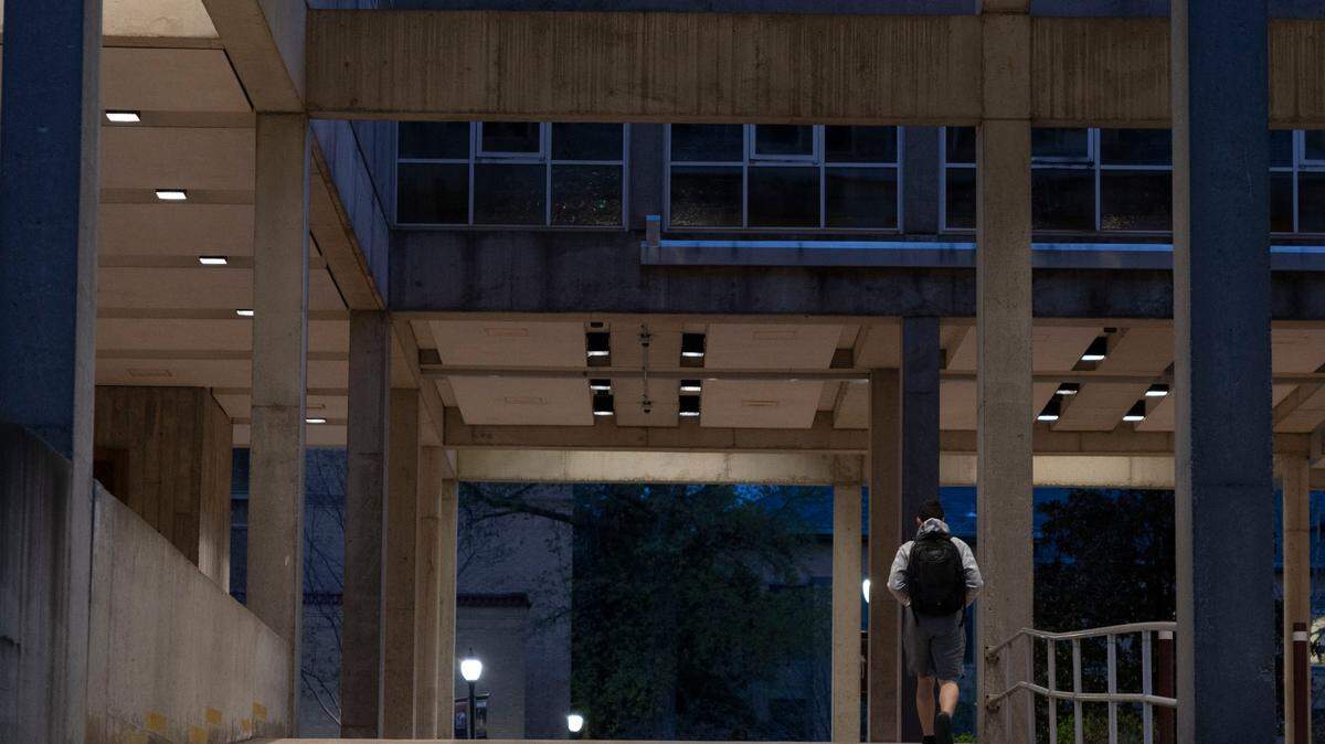 A student walks through the Faner Hall breezeway late in the evening April 9, 2025 at Southern Illinois University in Carbondale, Illinois. 