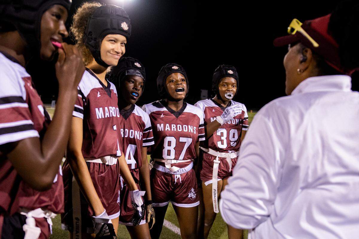 From left: DeNylah Franklin (88), Milayna Lewis (1), A’Aliyah Paulette (14), Chaun’Shay Suggs (87) and Destini Turner (39) listen as Defense Coordinator Karen Chrism gives them feedback before returning to the field for a game against Belleville East on Wednesday.
