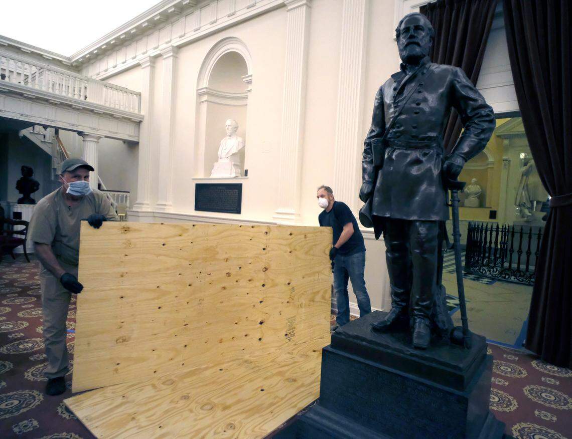 Workmen prepare to load up a statue of Robert E. Lee on July 23 at the Virginia State Capitol in Richmond. Political pressure has led officials to remove all Confederate statues and plaques.
