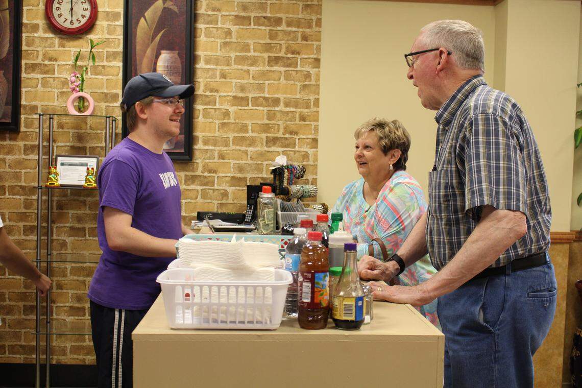 Shaun Nelson, left, explains the menu at Kain Tayo Filipino Cuisine in Trenton to customers Ann and Bill Zeisset, who hadn’t eaten at the restaurant until recently.
