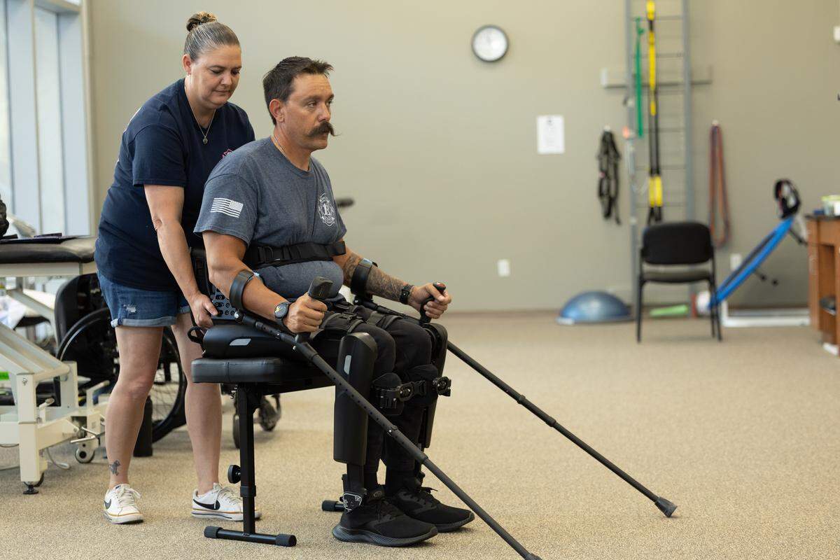 Patty Blanchard helps her husband Brad stand using his new exoskeleton during physical therapy in St. Louis. Brad Blanchard hopes to participate in a stair climbing event 11 months from now to honor the victims of 9/11. “I may not be able to do the whole thing,” Blanchard said, “but I’m going to go up a few flights at least. I’ll be sweaty and exhausted, but I’m doing it.”