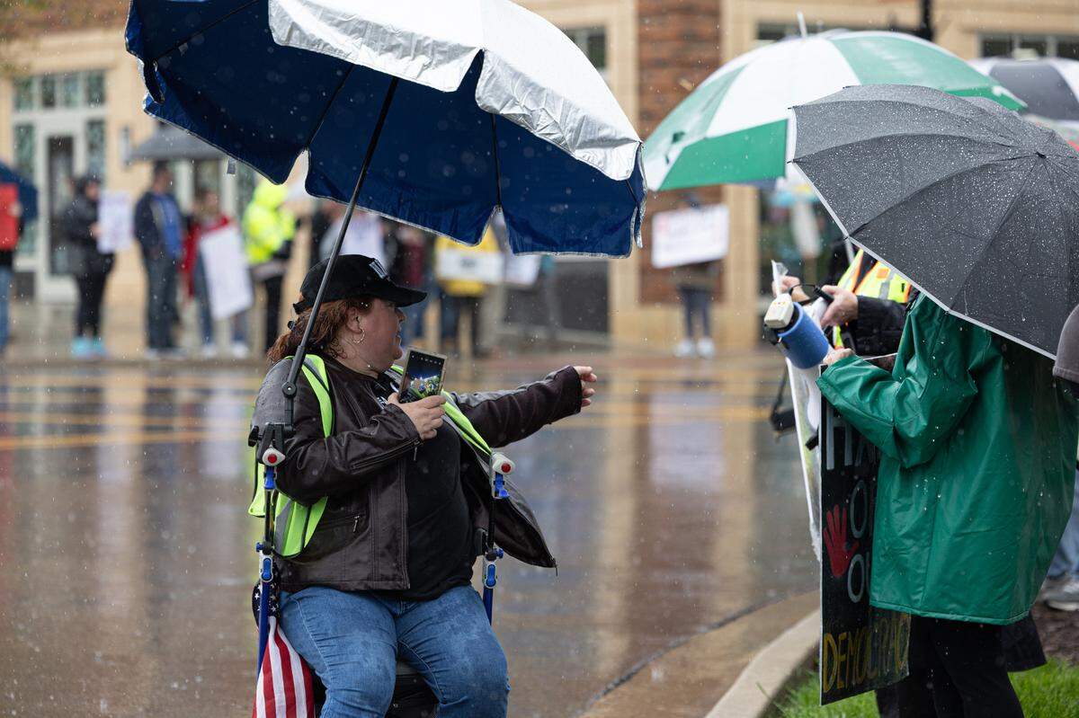 A member of Southwestern Illinois Democratic Women helps direct protestors in sign placement during Saturday’s protest.