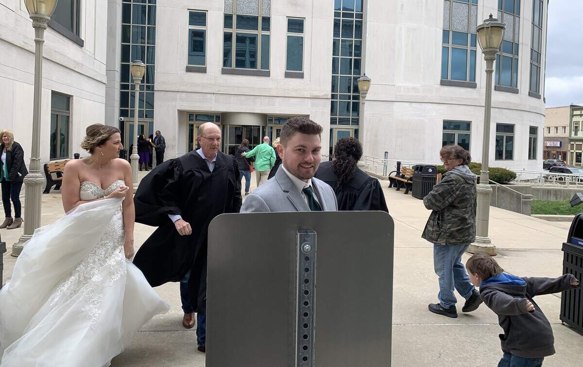 The black robe of Associate Judge Barry Julian blows in the wind Friday, when he and two other judges performed ceremonies for 12 weddings and civil unions outside Madison County Courthouse in Edwardsville.