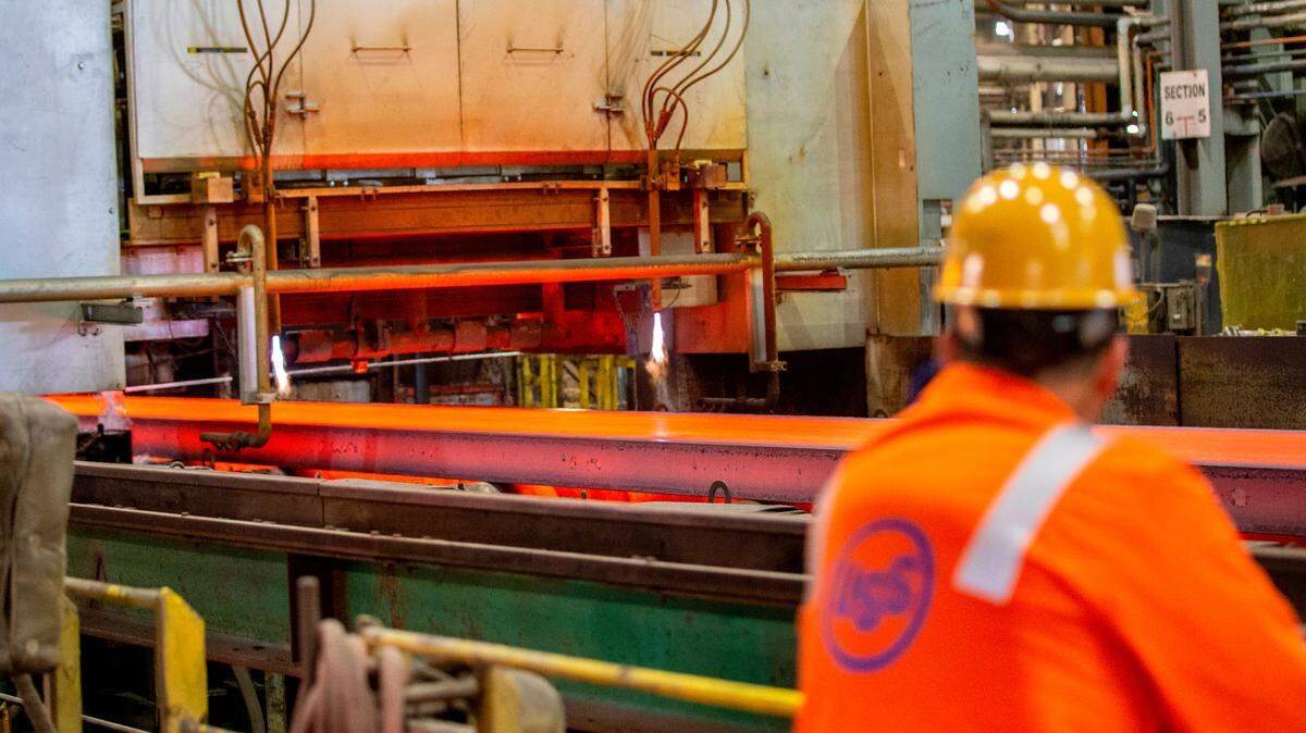 This file photo shows a U. S. Steel worker in Granite City watch a slab of steel move through the production process.