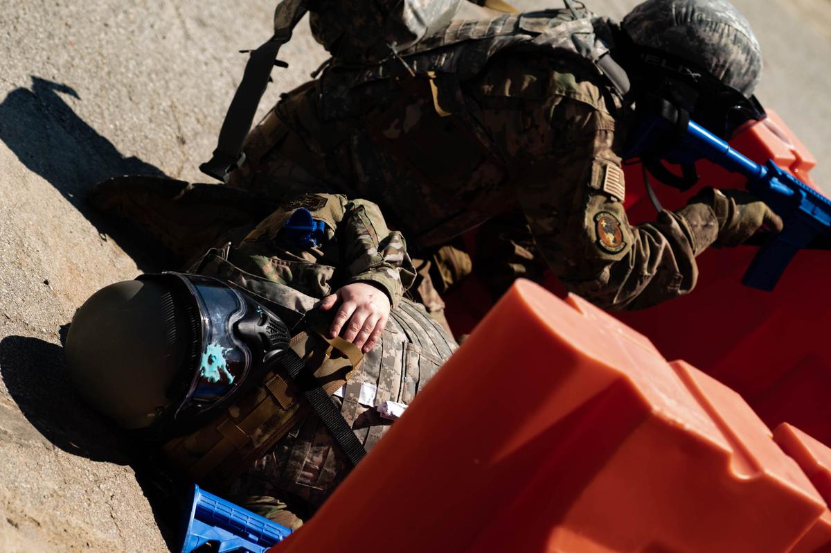 Members of Team Scott simulate care under fire during a Tactical Combat Casualty Care class on Scott Air Force Base. TCCC was created to help prevent combat casualties by providing trauma stabilization techniques allowing troops to receive life-saving treatment.