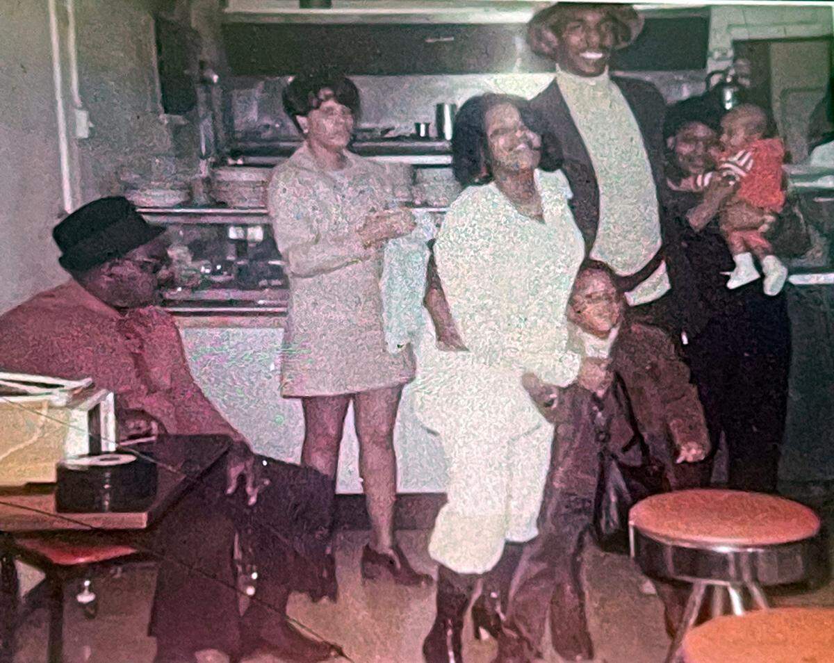 Dianne Ritchett and her family pose for a photo in the soul food restaurant mother Carrie Mae Stover-Spencer ran on 15th Street in East St. Louis. Ritchett is getting ready to move back to East St. Louis, her hometown, after more than 40 years in Seattle.