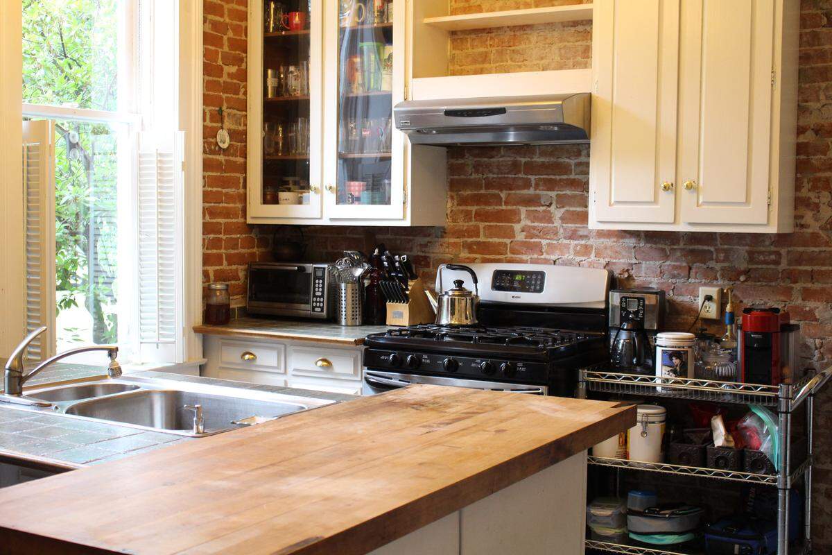 The kitchen in the McCullough family’s 1874 brick home on Abend Street in Old Belleville Historic District has a high ceiling, tall windows and an exposed brick wall.