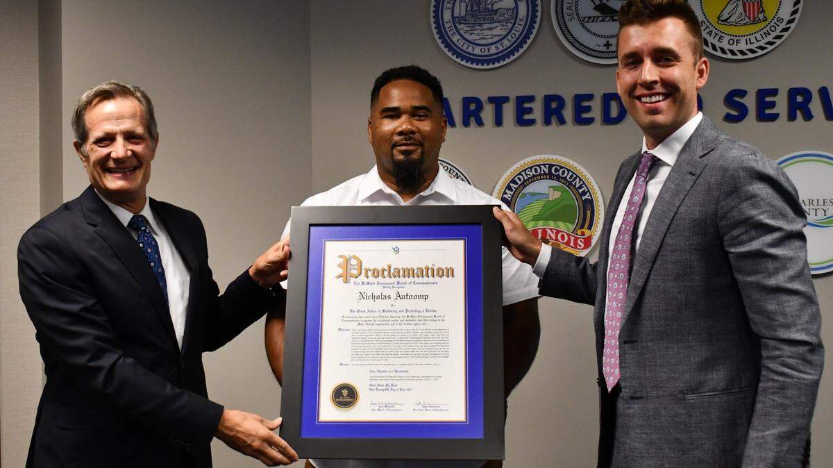 Nicholas “Nick” Autoomp, center, is presented a proclamation for exceptional service by Taulby Roach, Bi-State Development President and CEO, left, and Justin Zimmerman, vice chair of the agency’s board of commissioners.