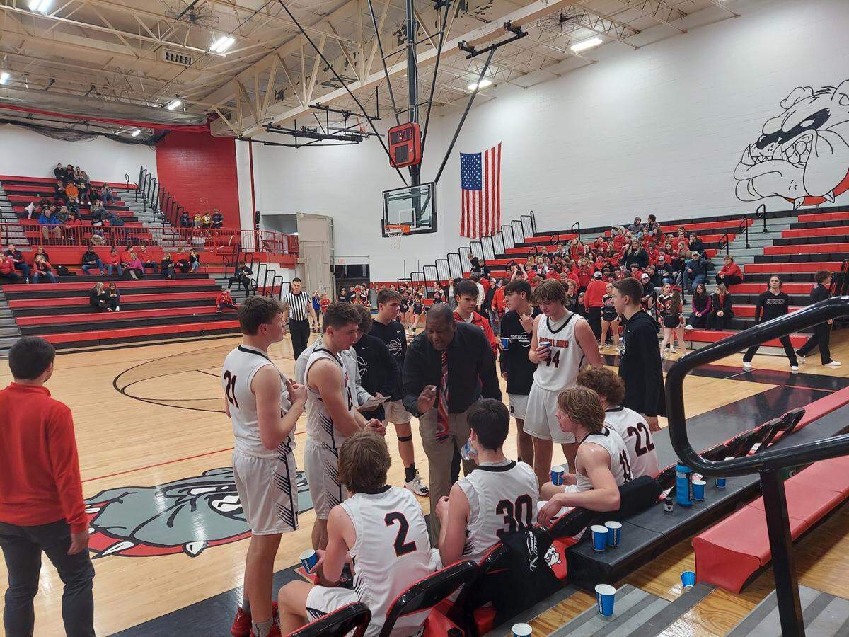 Highland coach Deryl Cunningham discusses strategy with his team during a fourth quarter timeout in a Mississippi Valley Conference game against Mascoutah. The Bulldogs ultimately prevailed 51-45.