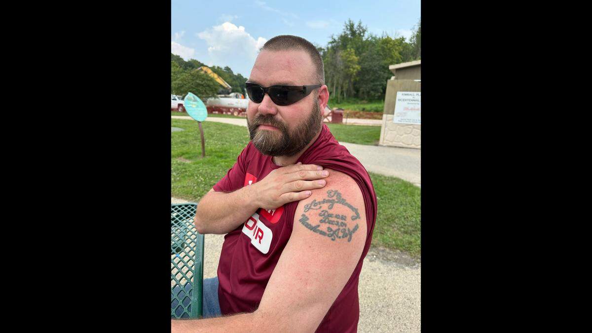 Ben Theis holds his shirt up to reveal his tattoo on July 25, 2024. Theis was Matthew Wyatt’s childhood friend, and he got the tattoo after he died in December 2004.