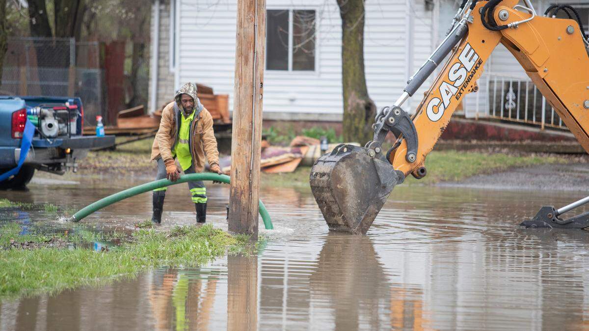 Workers with the city of Cahokia Heights try to pump water out of Piat Place to reduce flooding in the neighborhood. Residents said the city was on the scene during the rain but were unable to keep up with the flooding overnight.