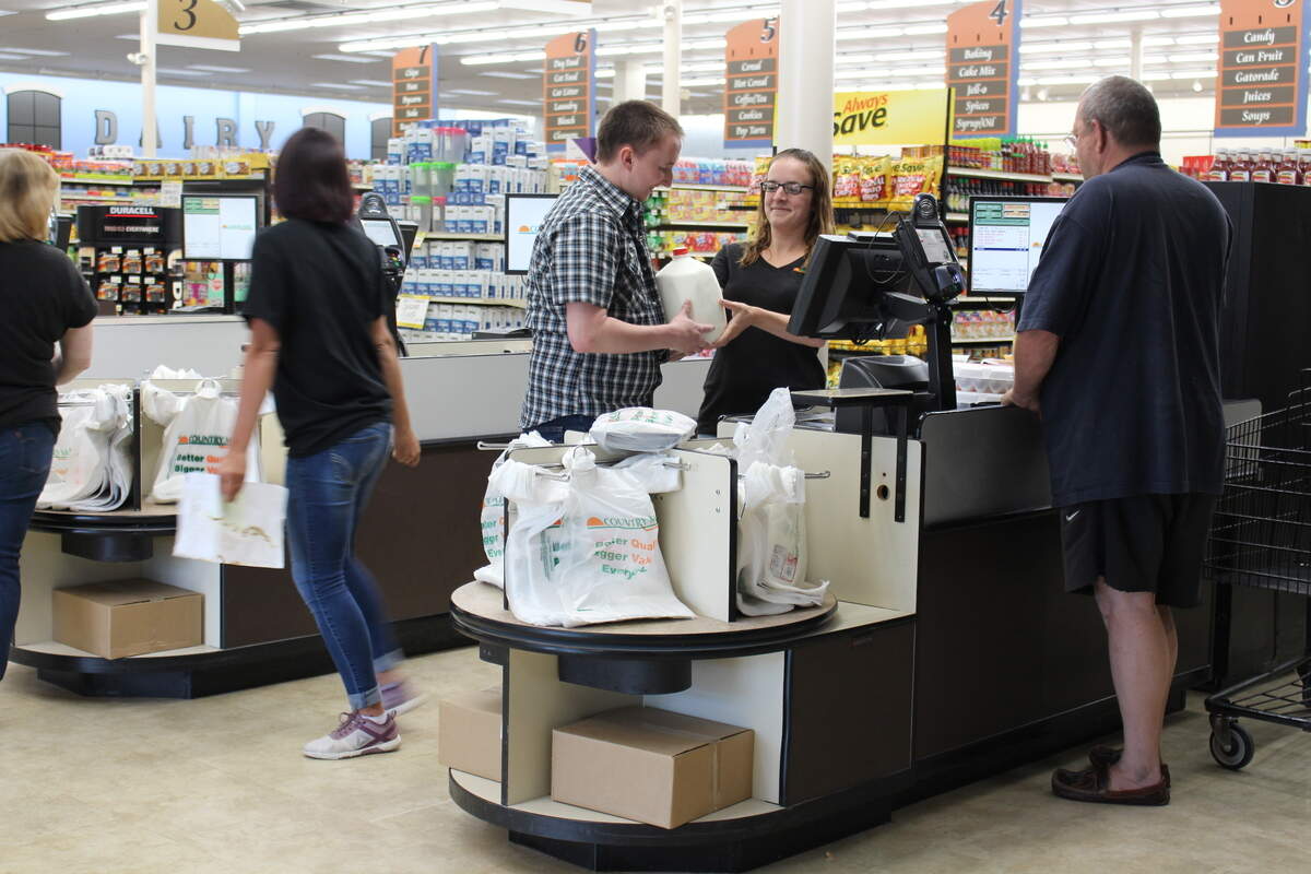 Employees Alyssa Phillips, center, and John Frye wait on a customer at Freeburg Country Mart, which opened Tuesday off State Street. The new store has grocery, produce, dairy, meat, deli, bakery, frozen and liquor departments, as well as a pharmacy.