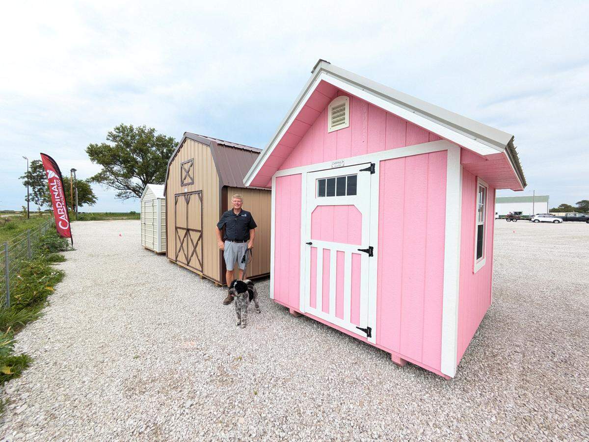 Dennis Haas, owner of HaasHold Storage Solutions, stands with samples of available storage sheds.