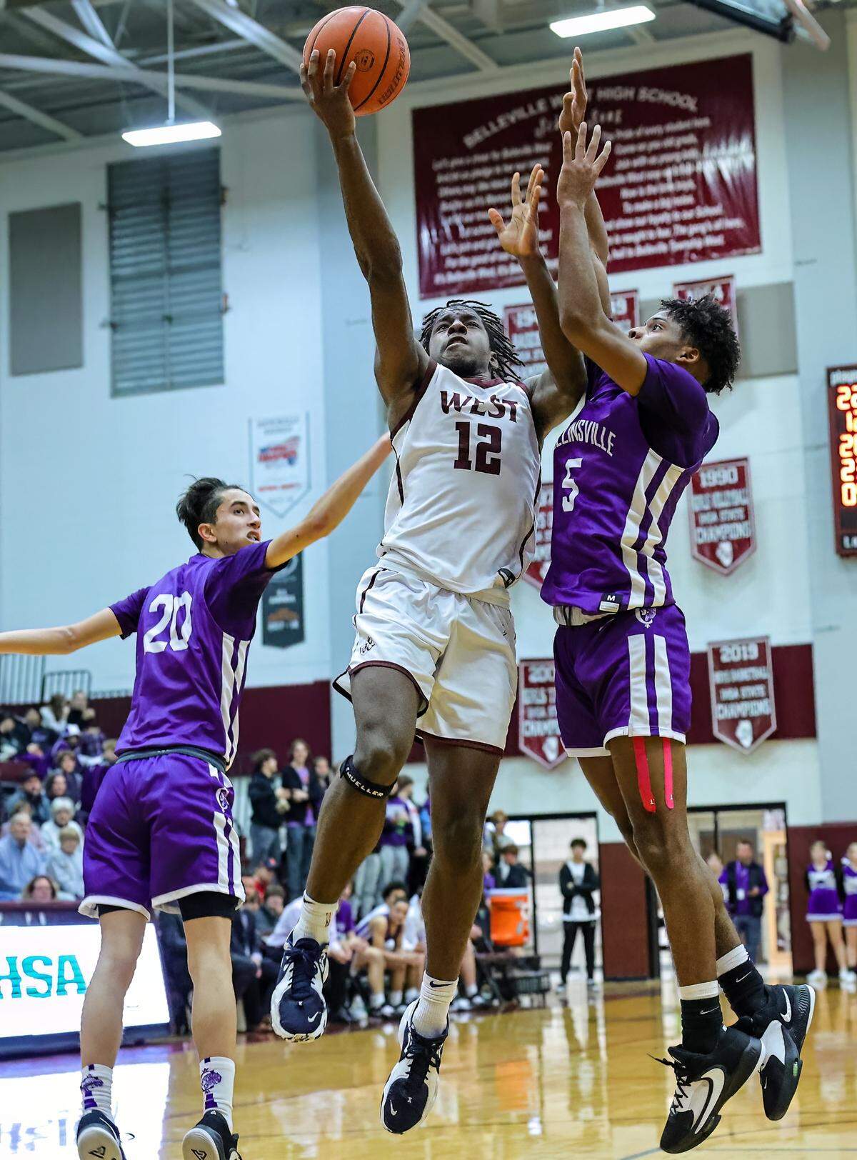 Collinsville’s Jamorie Wysinger defends against Belleville West’s Myles Liddell as he lays the ball up during Friday night’s Southwestern Conference game. The Kahoks ultimately posted a 71-60 victory.