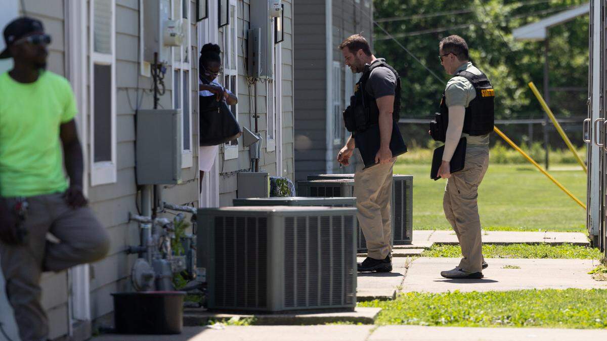 Illinois State Police canvas door-to-door at the scene of a homicide in the Thomas Terry Apartments complex in Brooklyn on Tuesday.