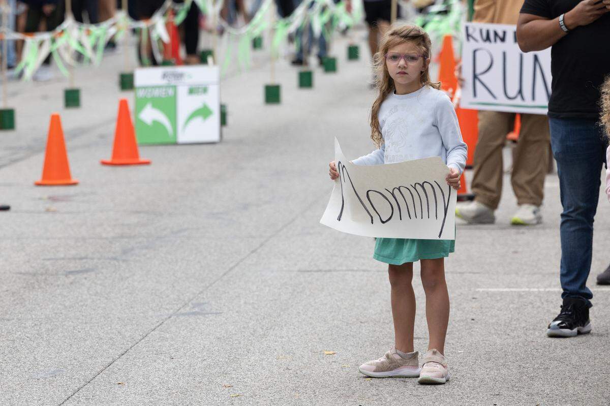 A child holds a sign up for their mother at the Belleville Marathon on Sept. 28, 2024.