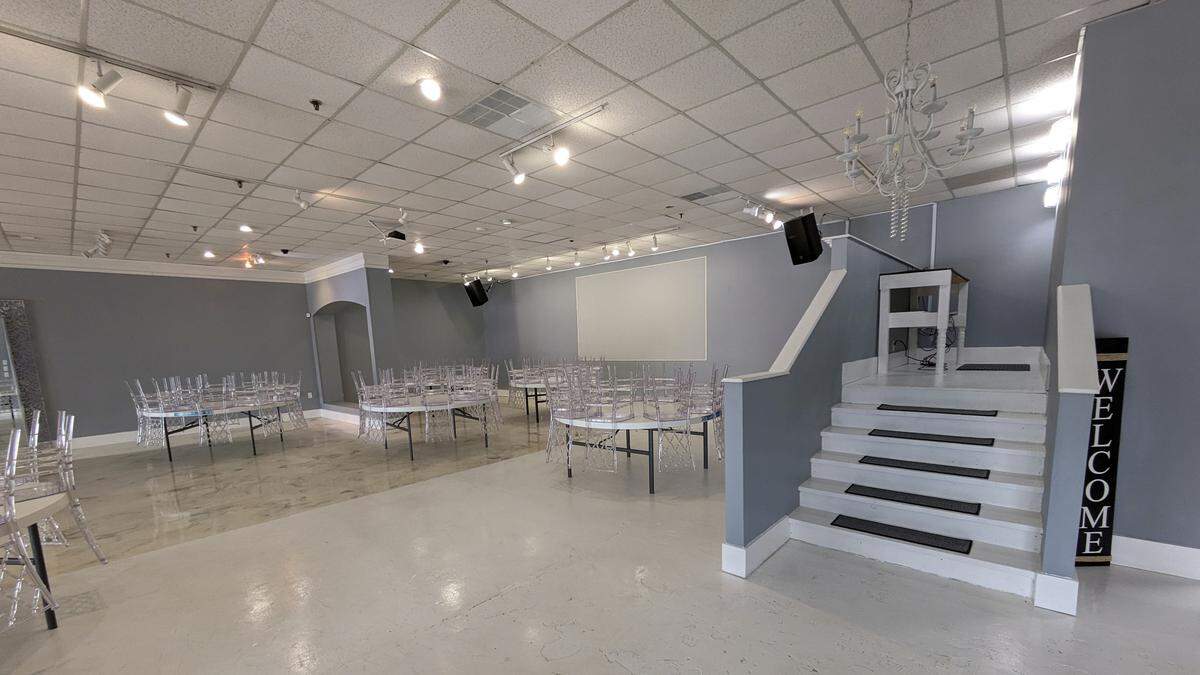 A projection screen and raised platform area at Bliss Events in Belleville
