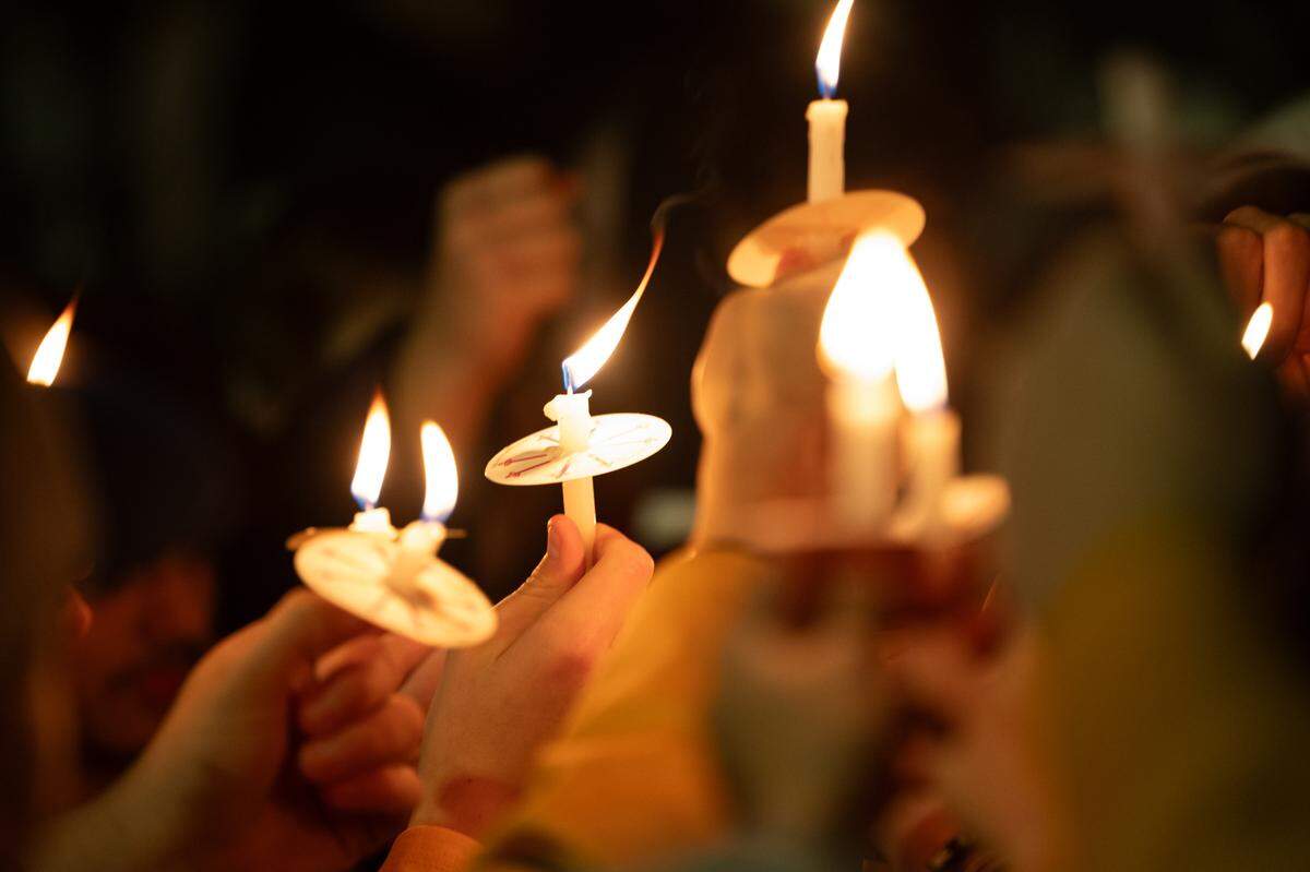 Teammates and opponents of 16-year-old hockey player Colin Brown hold up candles as they chant “We pray for you, 72.” Friends gathered for the vigil at the McKendree MetroRecplex in O’Fallon Monday.