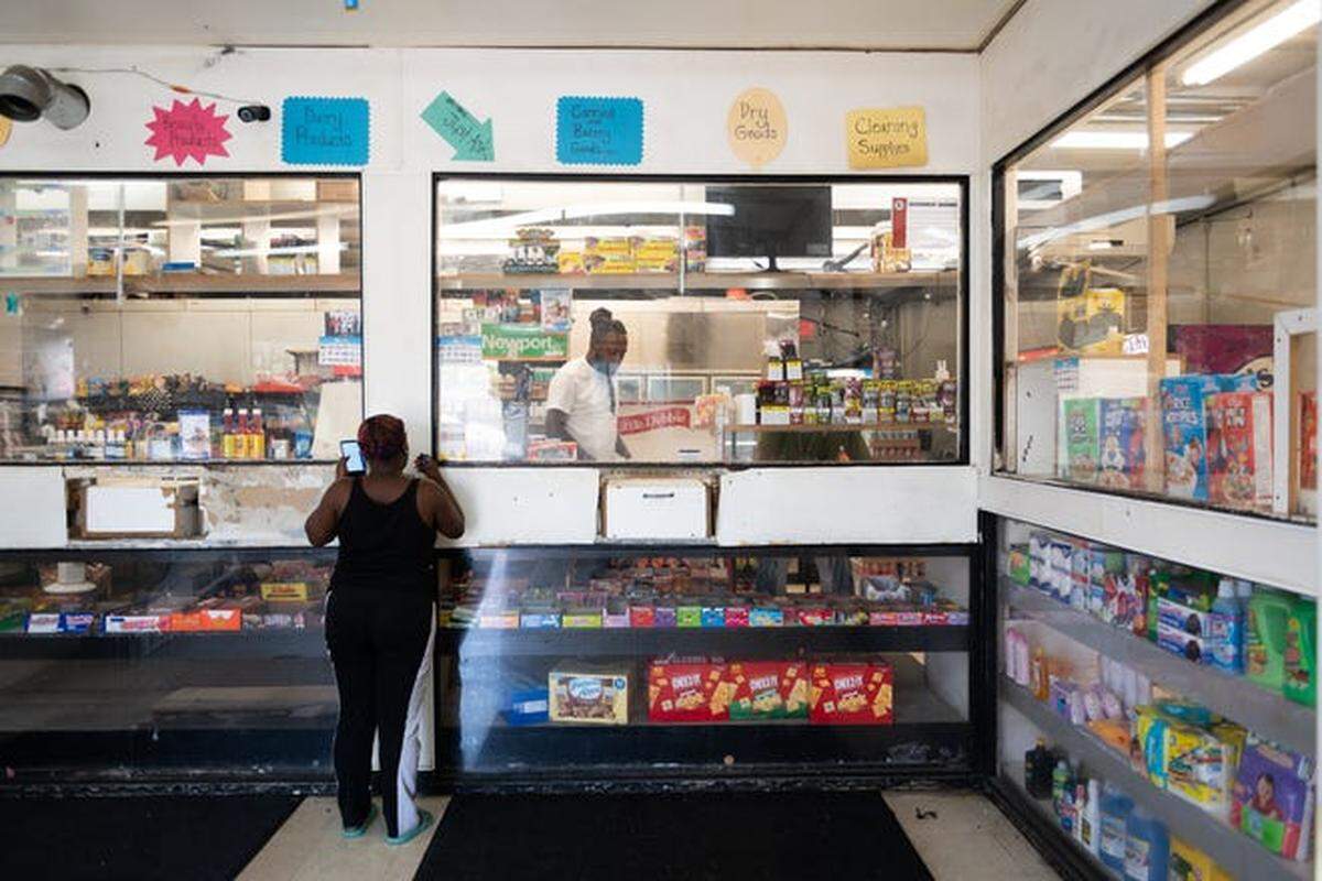 A woman places an order at Charlie’s Convenient Market in Washington Park.