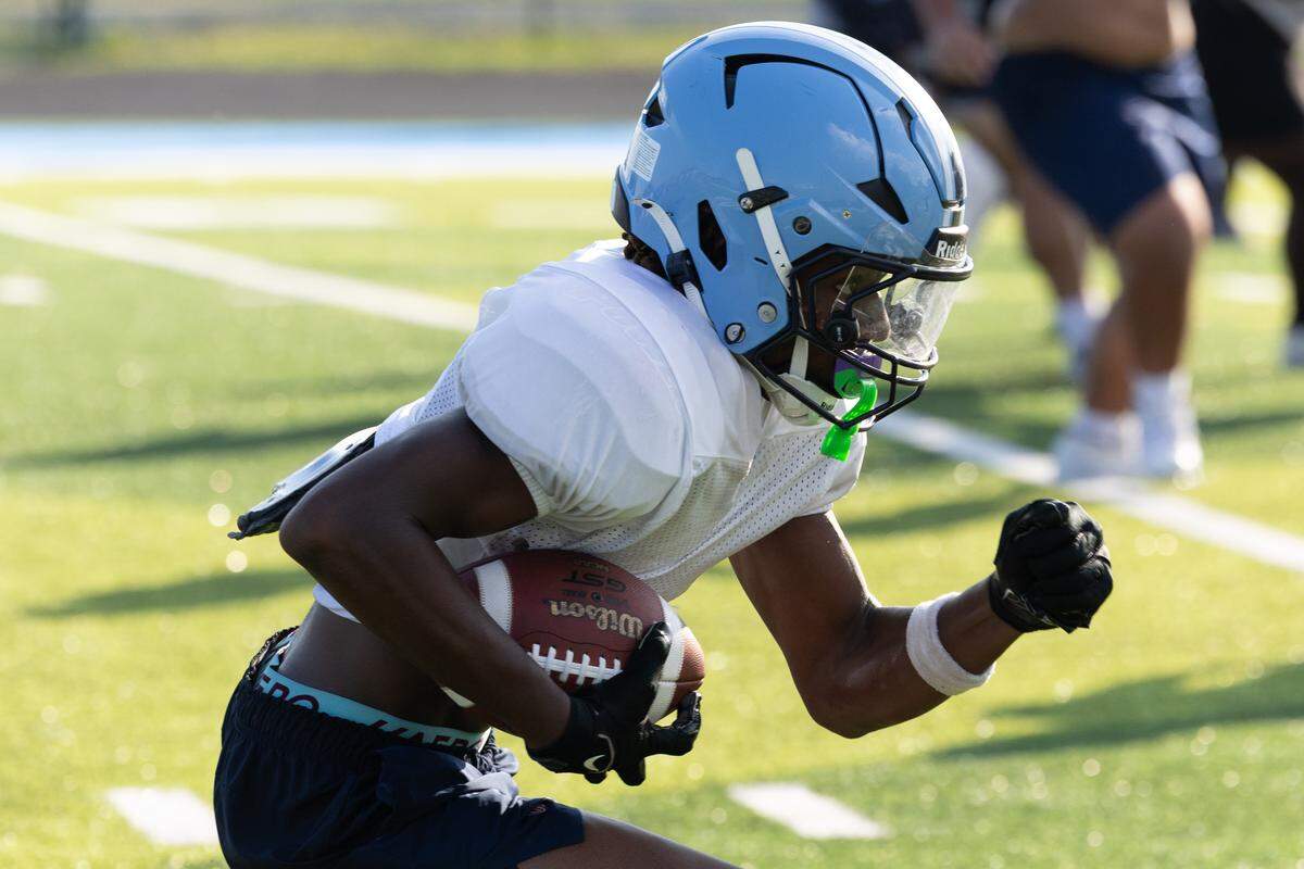 Belleville East junior running back CJ Willis runs drills during the first week of football practice.
