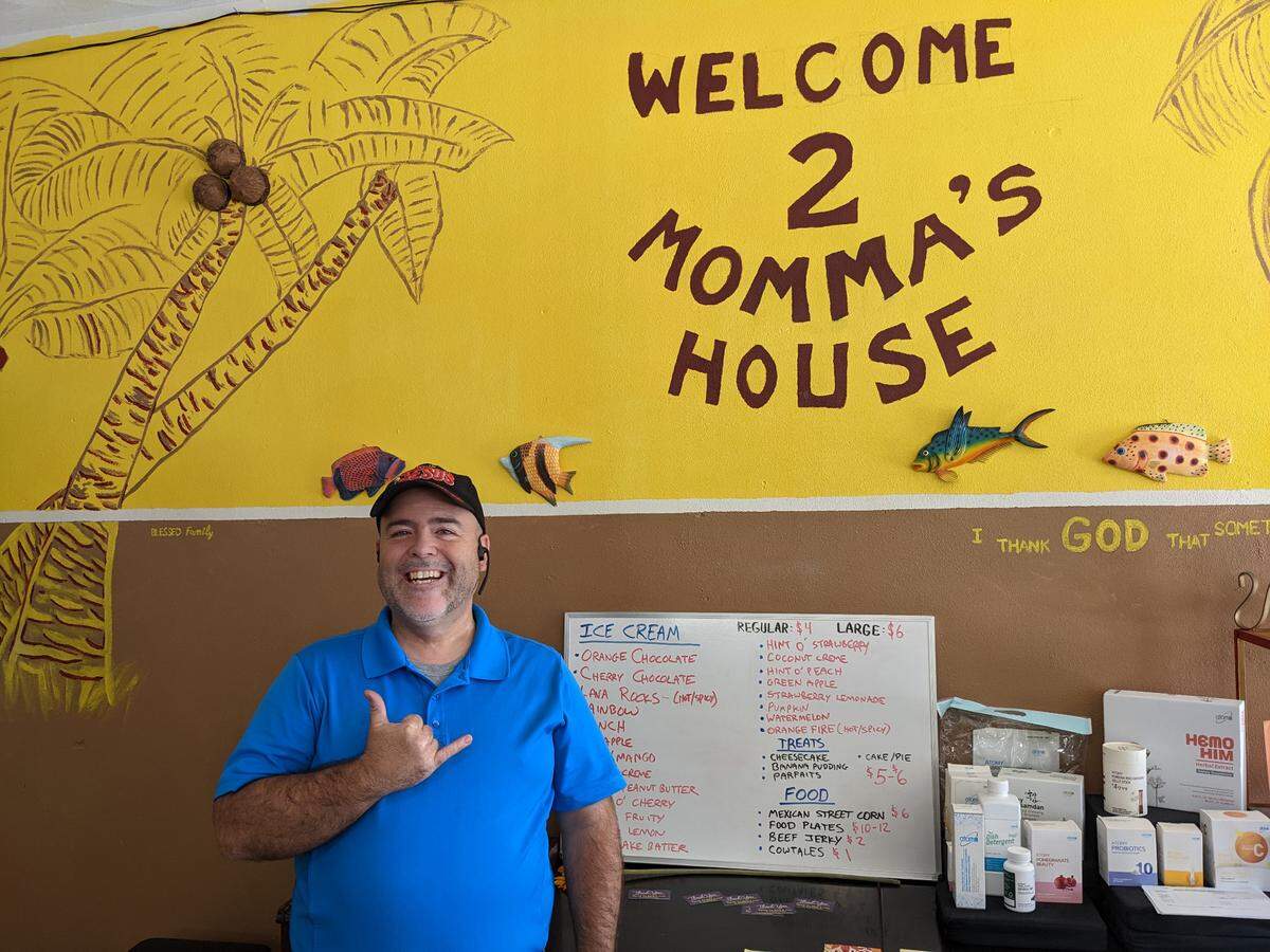 Pastor Denon Minney, manager at Speak to Miss J in Lebanon, stands in front of the menu board that includes 21 flavors of ice cream.