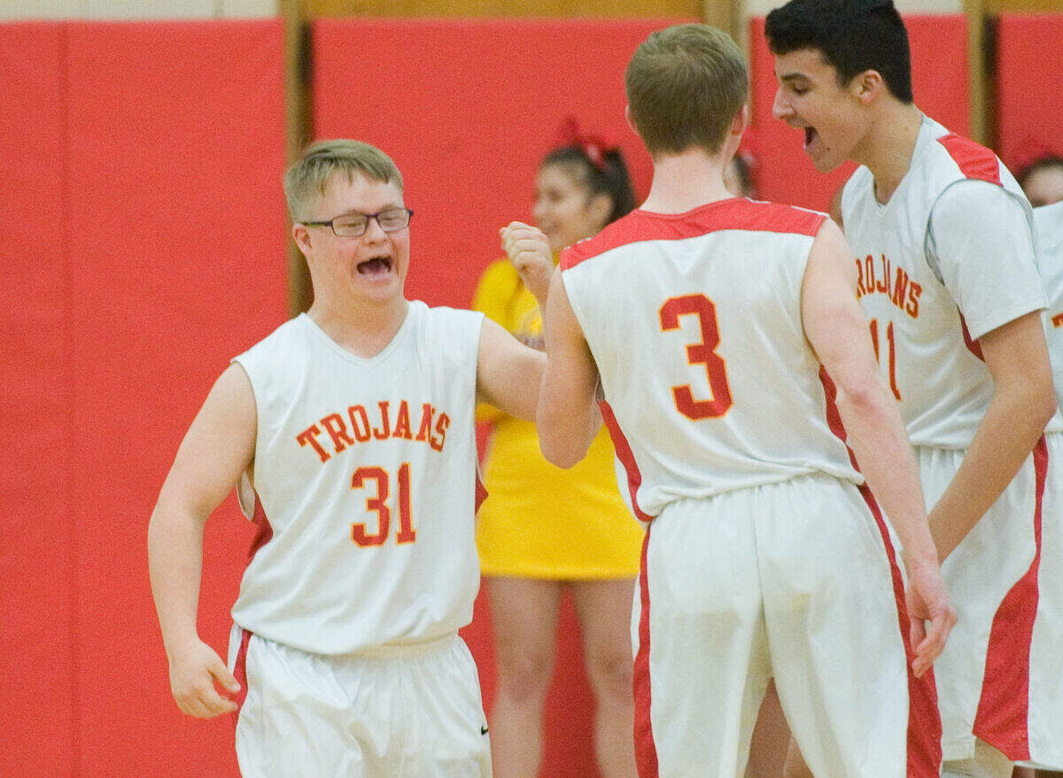 A photo by Kevin Kilhoffer shows a triumphant Jimmy Peterlich, left, smiling as he's congratulated by teammates after making a 3-point shot as Charleston played Mount Zion at Charleston High School on Friday.