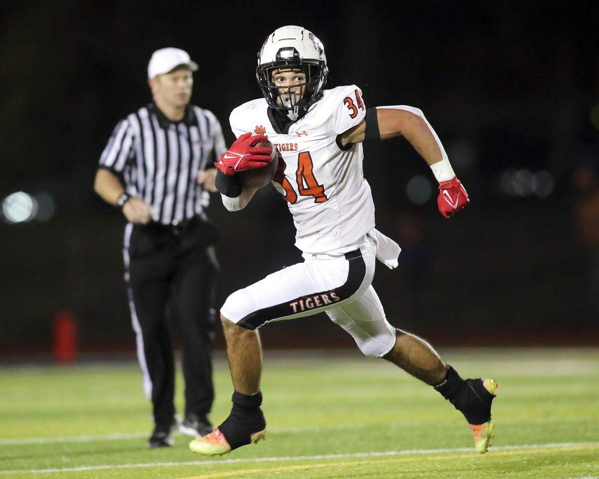 Edwardsville’s De’Shawn Larson carries the ball during an IHSA Class 8A playoff game Saturday night against O’Fallon. The Tigers ultimately posted a 43-36 victory.