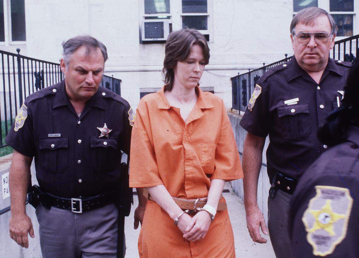 Madison County Sheriff’s Department deputies escort Paula Sims outside the Edwardsville courthouse in 1989. She was later convicted of murder.