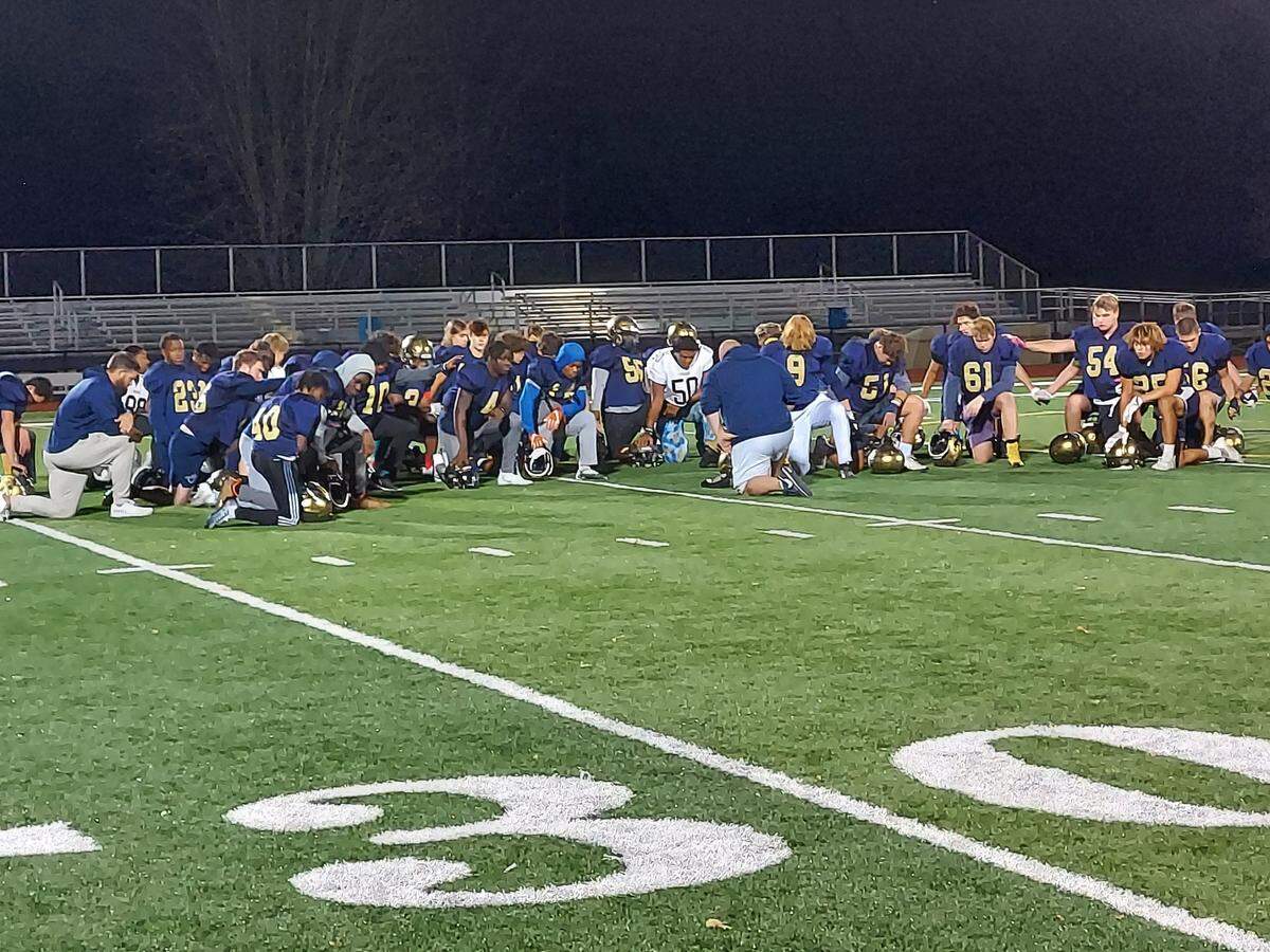 Althoff football coach Austin Frazier leads his team in prayer at the end of practice Tuesday night. Frazier and the Crusaders are gearing up for their IHSA Class 2A quarterfinal game Saturday at Johnston City.