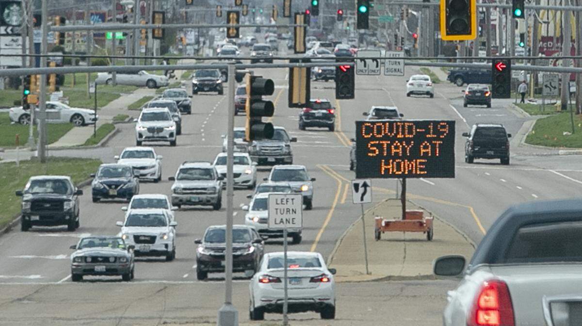 Traffic on U.S. 50 near Interstate 64 in O’Fallon passes a sign asking people to stay home to help slow the spread of coronavirus or COVID-19.