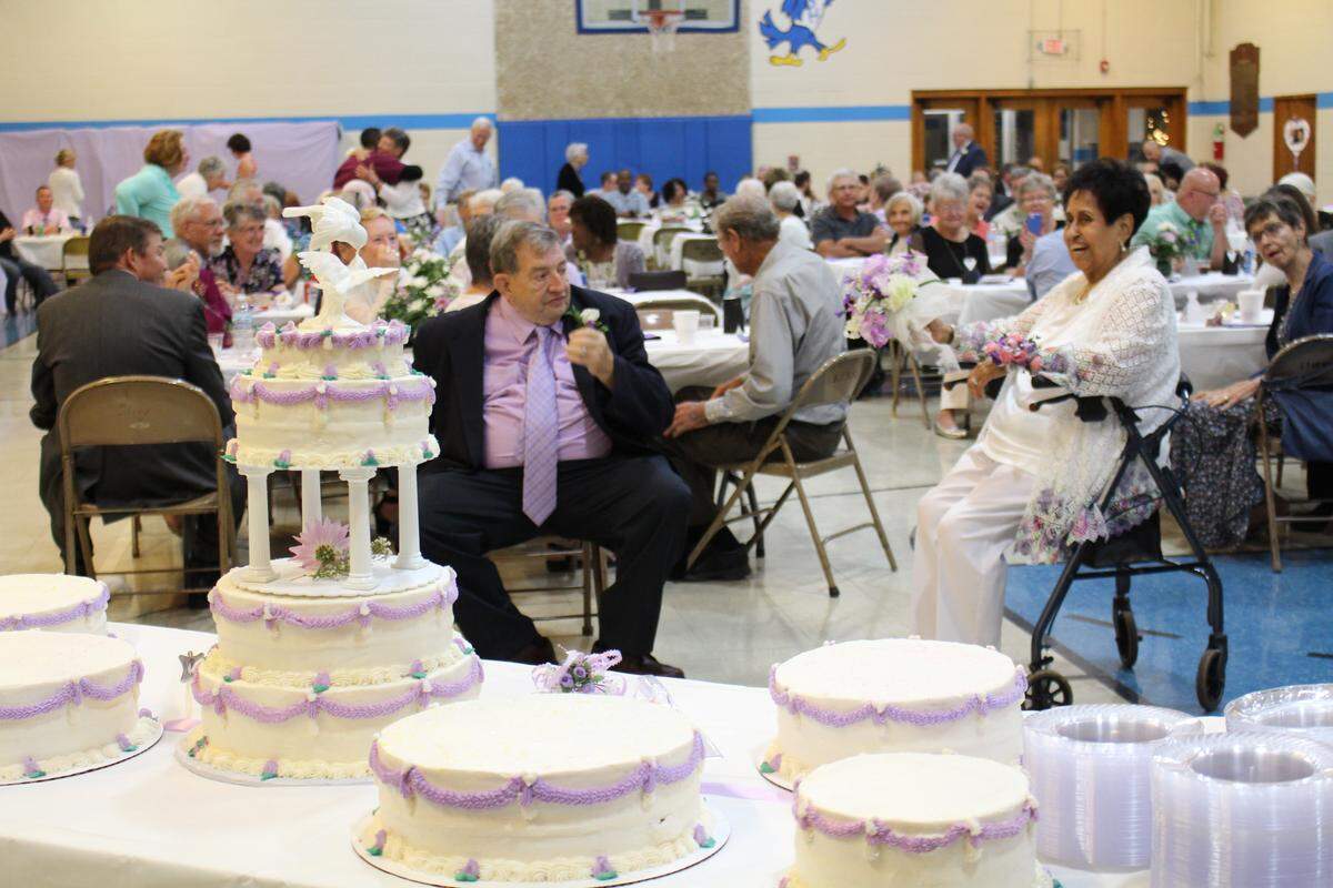 Julie Hubbard prepares to throw her bouquet to single women as her new husband, Joe Hubbard, looks on during their wedding reception Friday night.