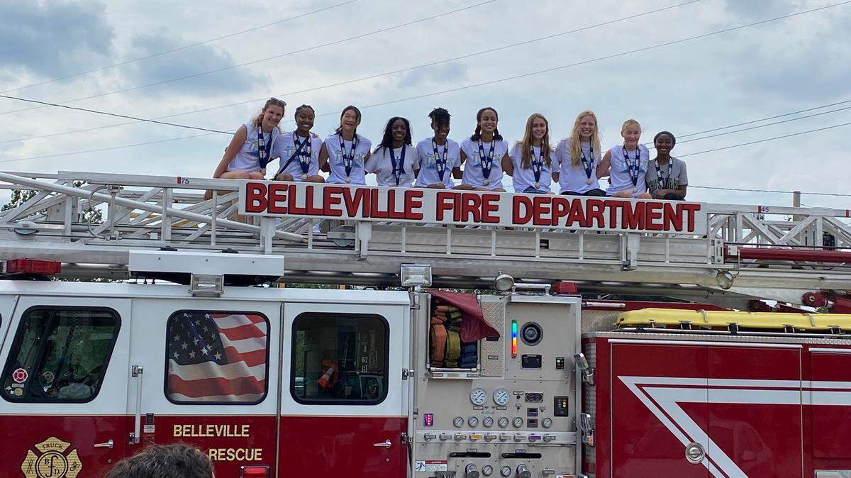 Members of Althoff Catholic’s girls track team pose on a firetruck during Belleville’s celebrations of the school’s three state championships on Sunday, June 20, 2021.