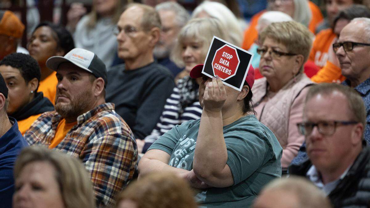 A Troy resident holds a sign reading “Stop data centers” during a February public meeting regarding a possible data center in the area.