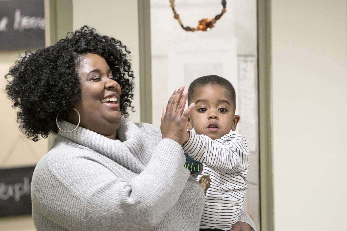 Melody Peterson and her 2-year-old son Princeton high-five after Melody arrived to pick him up from the SIUE Early Childhood Center.