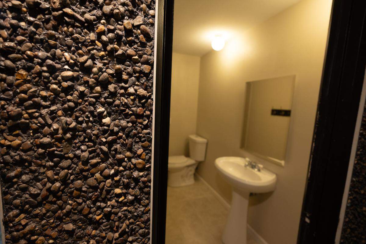 Small original details were kept throughout the home, including this pebbled wall leading to the downstairs bathroom.