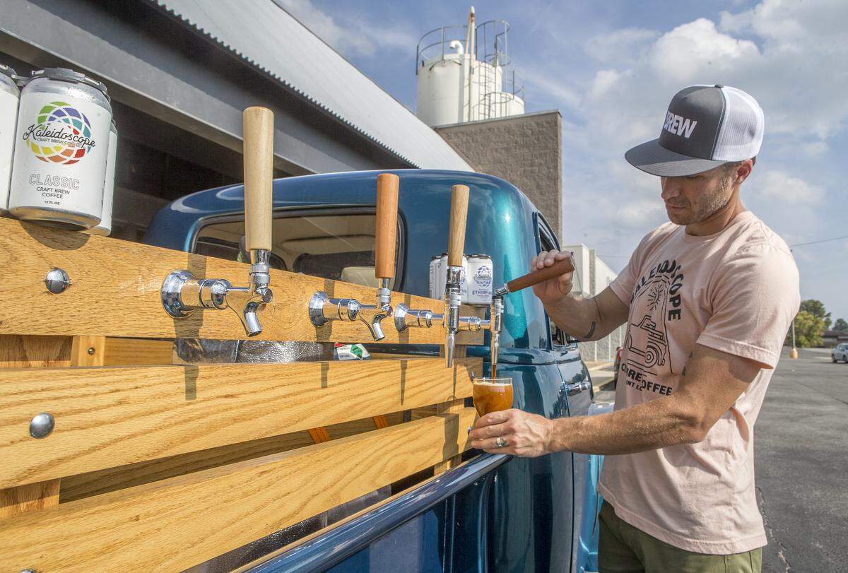 Chris Thele, co-founder of Kaleidoscope Craft Brew Coffee, pours coffee from one of the taps on his mobile coffee dispenser.