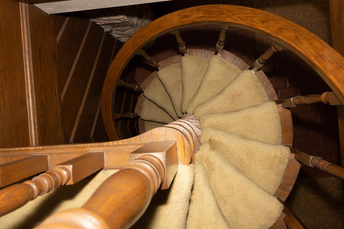 A large spiral staircase made of hardwood leads down to the sauna and bar rooms below.