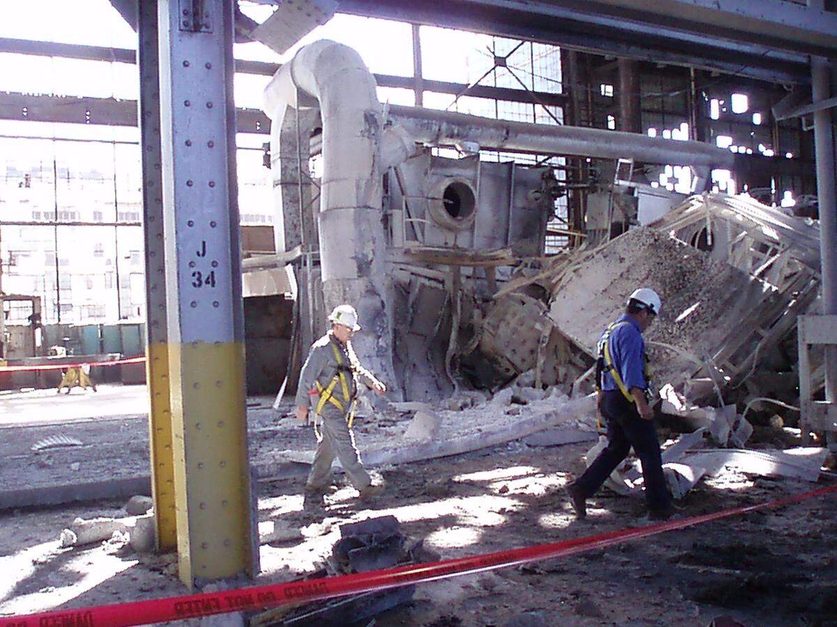 State inspectors walk past ruins of a coil-reheating furnace at Magnesium Elektron North America in Madison after a 2010 fire.