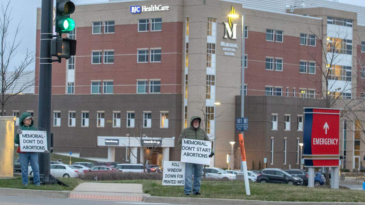 Abortion opponents who don’t want Memorial Hospital in Shiloh to start offering abortions to women carrying fetuses with “anomalies” hold signs and distribute flyers to drivers on March 7.