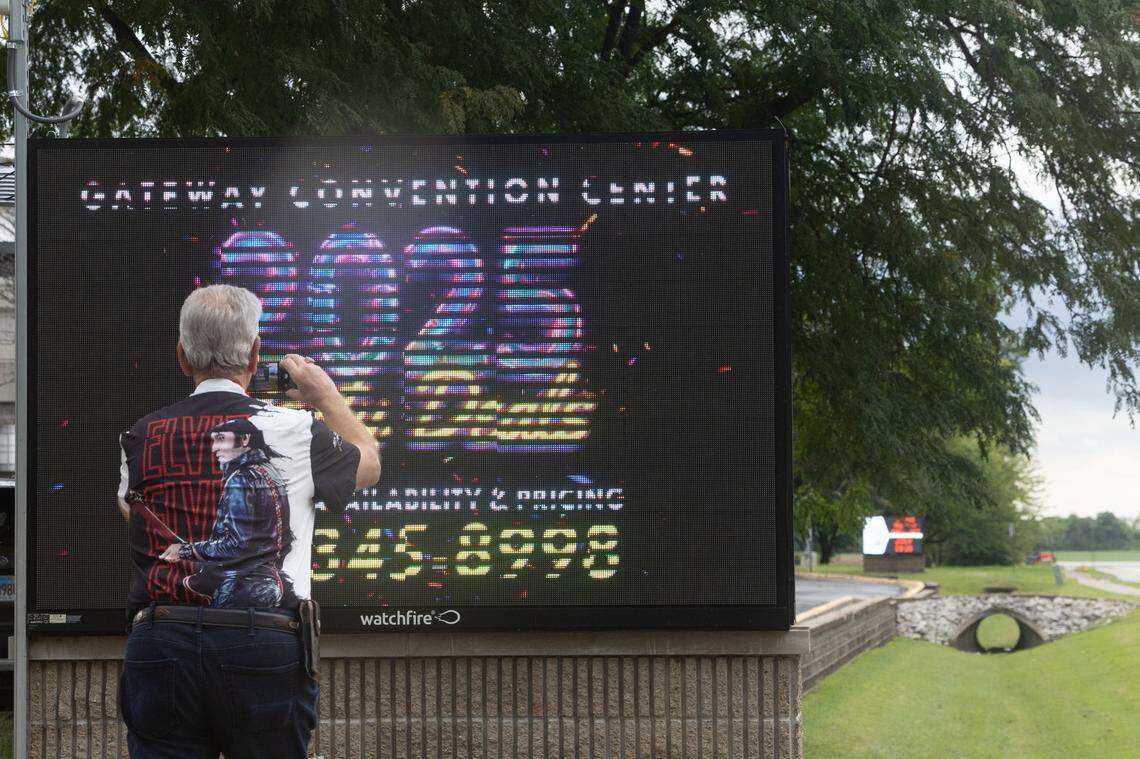 A fan takes a photo of the sign advertising the Elvis convention outside of the Gateway Convention Center in Collinsville.