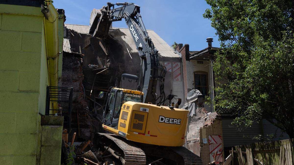 A track hoe operates from the top of a pile of brick, wood and other rubble on Wednesday at 1013 W. Main St. in Belleville. St. Clair County, which owned the building, hired Hayes Contracting to demolish it.