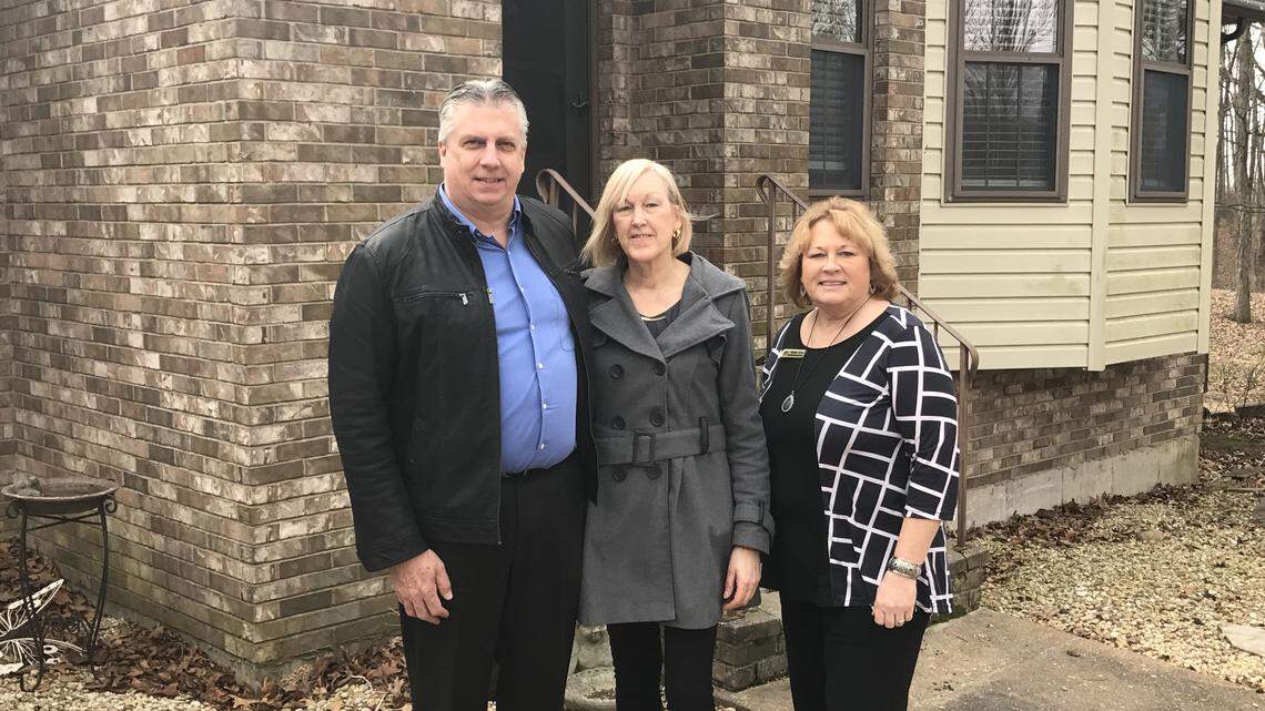 Steve and Linda Heimsath, left, with Joanie Willis of Bradford National Bank, in front of the residence on the Copper Dock property.