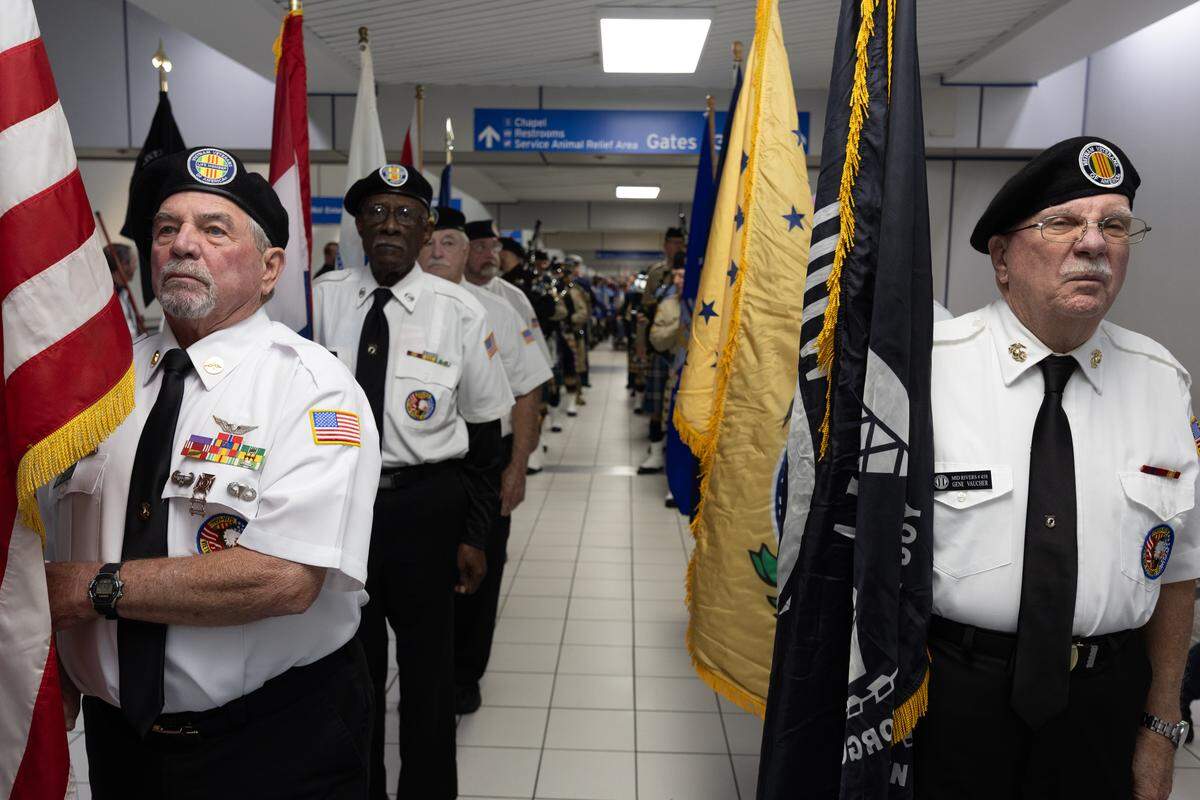 Members of the Vietnam Veterans of St. Louis wait to escort veterans from Greater St. Louis Honor Flight through Lambert airport.