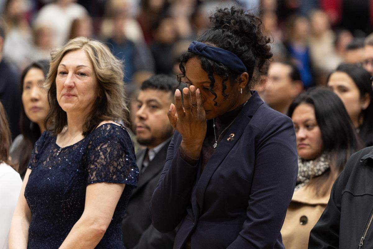 A newly naturalized U.S. citizen who migrated from The Netherlands is overcome with emotion during a performance of “America the Beautiful” by the Belleville West choir on Friday.