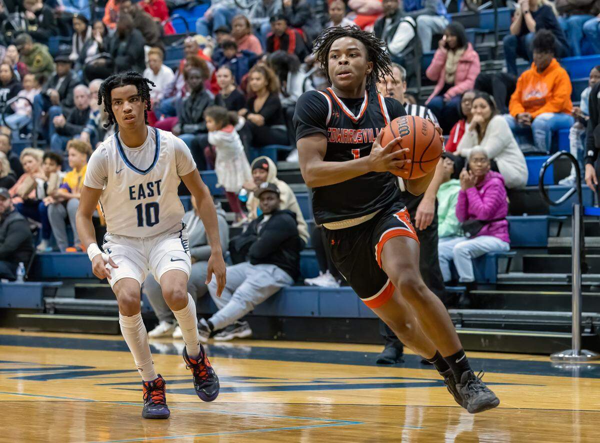 Edwardsville’s AJ Tillman drives to the basket during a Southwetern Conference game Friday night against Belleville East. The Tigers ultimately dropped a 57-47 decision.
