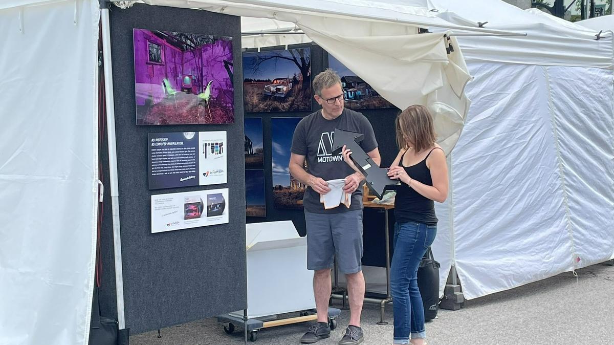 Photographers Katie and Chris Robleski get their booth ready Friday morning for Belleville’s Art on the Square this weekend. Their work is featured on this year’s official poster for the 21st annual Art on the Square.