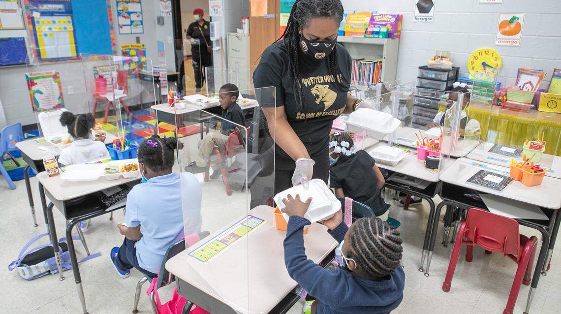 Brittany Green, principal of Younge Academy of Excellence in East St. Louis, passes lunches out to students on the first day of the school. Principal Green and other staff members will be distributing lunches out to students to avoid a crowded cafeteria. The school has many precautions in place to prevent the spread of COVID-19 and continue to educate students in person.