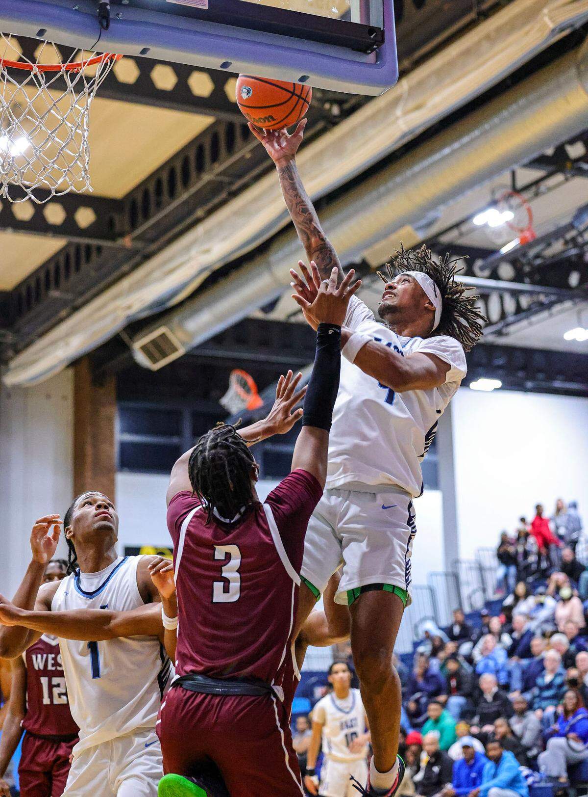 Belleville East Darien Singleton shoots over Belleville West’s Quincy Cotton during Friday night’s Southwestern Conference game. The Lancers ultimately prevailed 66-57.